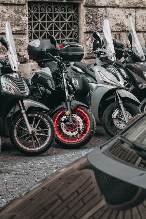 Scooters e ciclomotores elétricos estacionados na cidade — categoria que exige registro, placa e habilitação